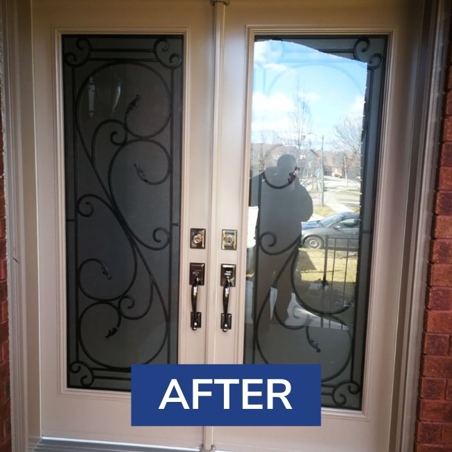 Double white entry door with 4/4 frosted glass inserts with wrought iron designs.