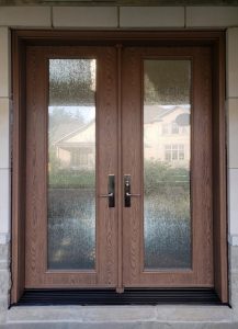 Double brown fiberglass entry door with glass inserts.