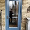 light blue steel door with glass insert