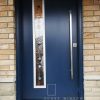 Modern Steel Single Door, custom 42 inch slab, offset narrow decorative glass with aluminum colour modern lite frame, painted blue exterior, 48 inch round pull bar system.