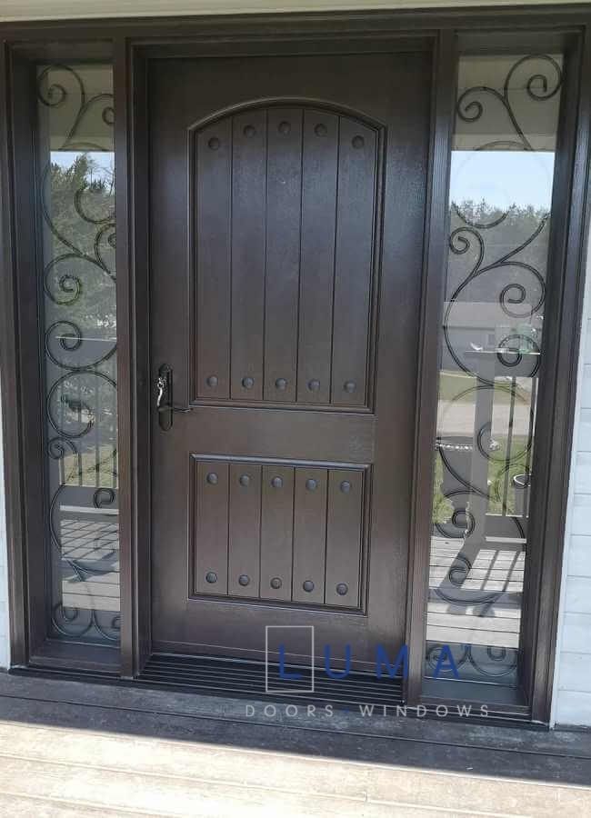 Fiberglass door system, Single oversized 42 inch x 8 foot tall slab. direct wrought iron sidlietes with full privacy, rustin nails (clovos) in door. stained dark brown exterior and interior, multi point locking system