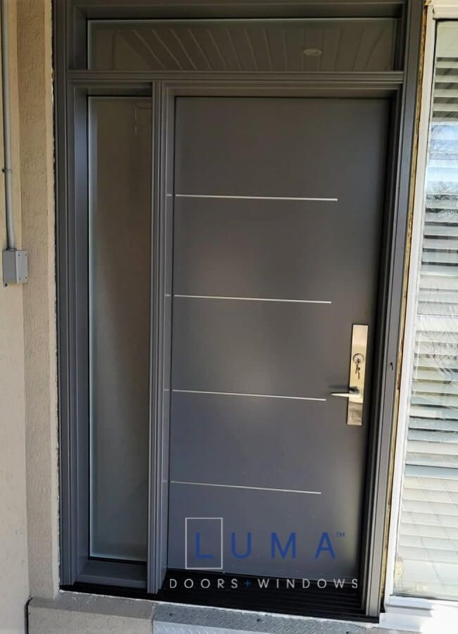 Modern Steel Door System, Uno style offset aluminum line design, Silver multi point locking system, painted gray exterior, direct privacy glass sidelite and transom
