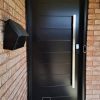 Modern Steel door, Novatech Mundo door slab, painted black exterior, 48 inch silver rectangular pull bar, keypad door lock