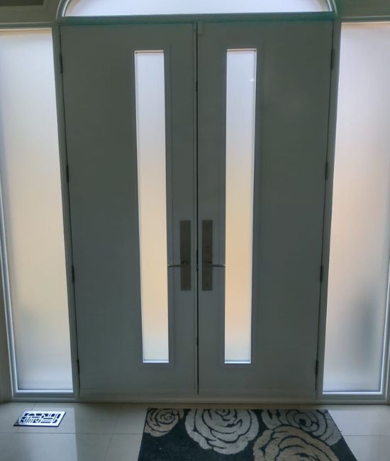 installing beige double doors with glass features